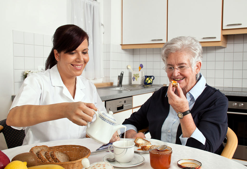 Home Care Professional Having Breakfast with an Elderly Woman