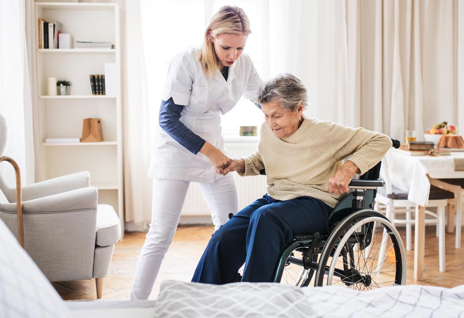 Home Care Professional Helping Elderly Woman Out of a Wheelchair